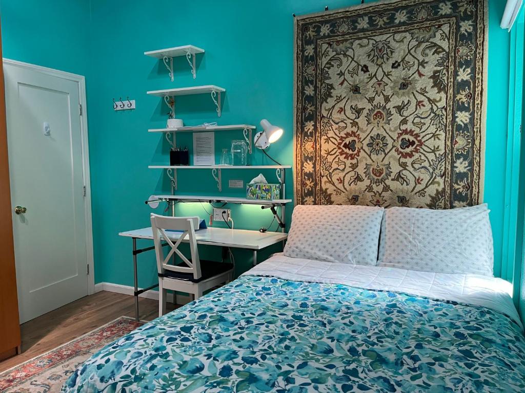 Dormitorio azul con cama y escritorio en NovaGarden en San Diego