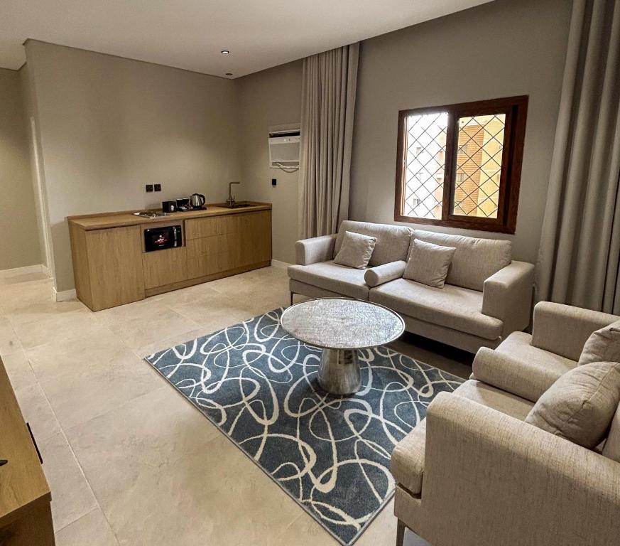 a living room with two couches and a table at Maz Apartments in Al Madinah