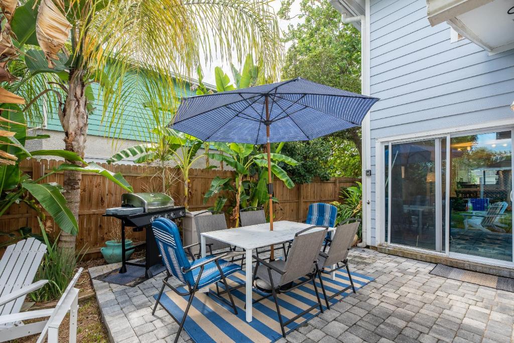 ein Tisch und Stühle mit einem Sonnenschirm auf einer Terrasse in der Unterkunft Jax Vacations 1/2 Mile to Beach, 2 bedroom townhome pet friendly in Jacksonville Beach