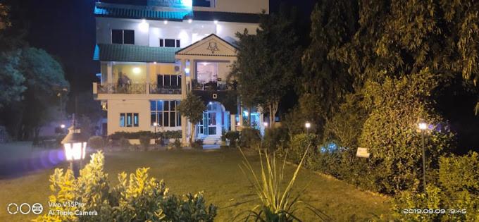 ein großes Haus in der Nacht mit eingeschaltetem Licht in der Unterkunft Hotel Amrit Resort in Alwar