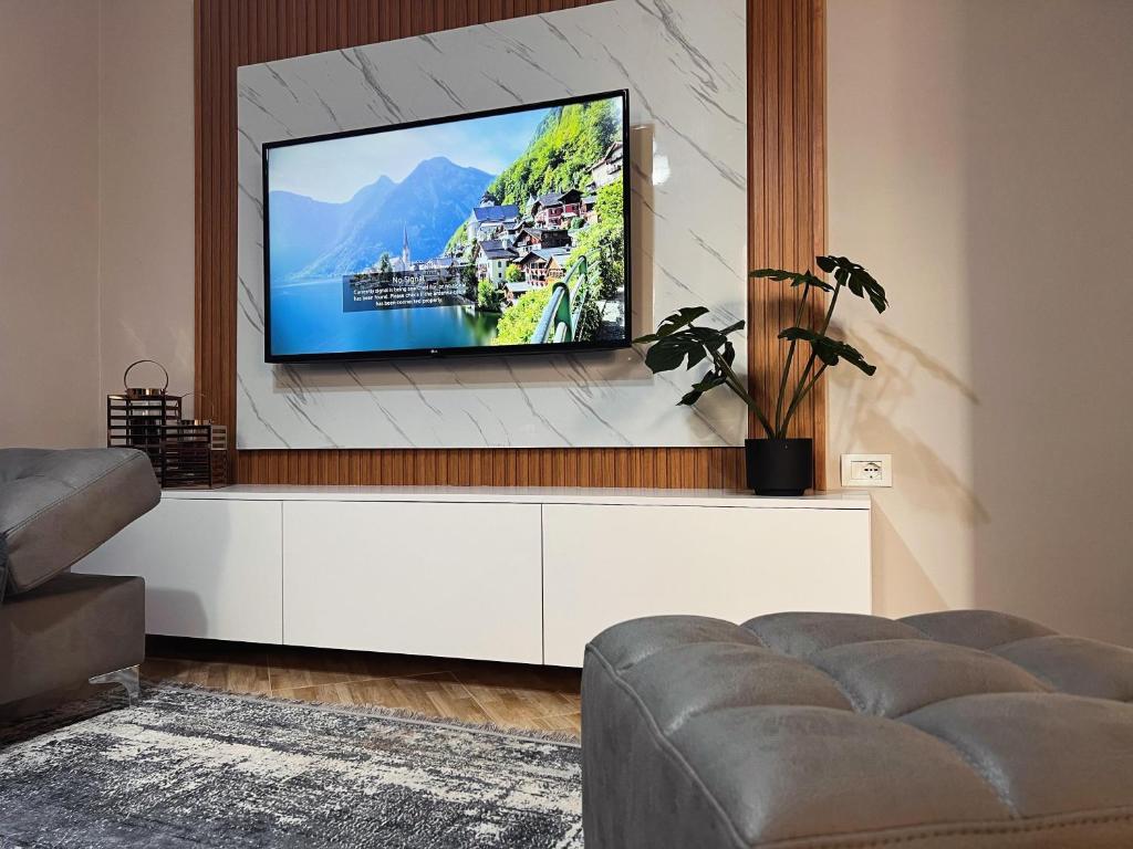 un soggiorno con una TV a schermo piatto su una parete di New modern Tirana apartment a Tirana