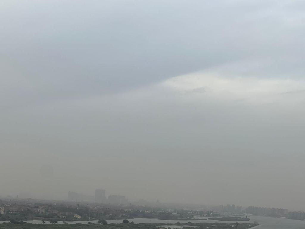 a foggy view of a city with a river and buildings at شقة فندقية فاخرة in Al Ma‘şarah