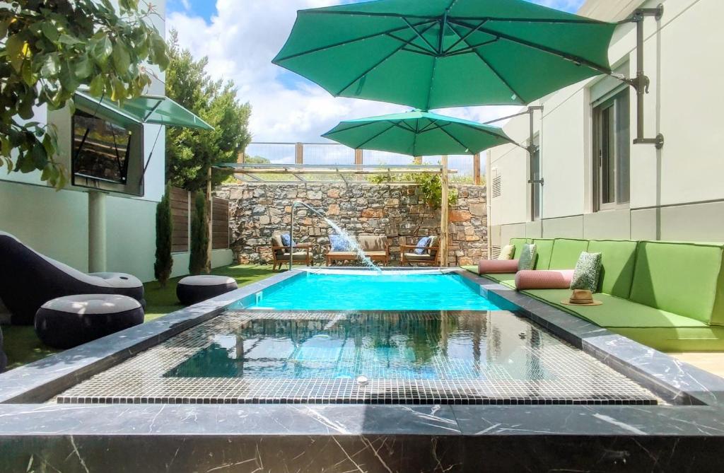 a swimming pool with an umbrella next to a building at Villa Salvia - Country style luxury & a captivating poolscape in Áyiai Paraskiaí