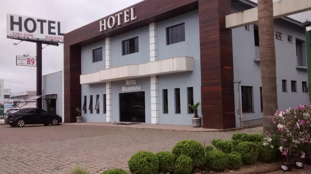 a hotel with a car parked in front of it at Hotel Manayara in Campo Largo