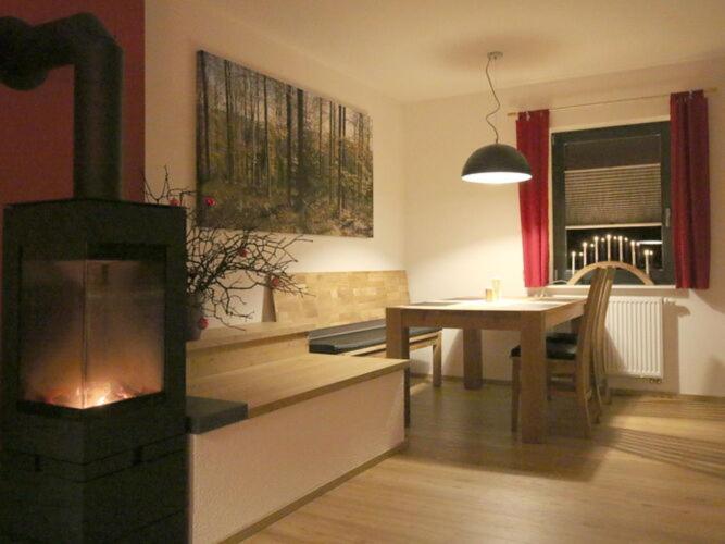 a living room with a fireplace and a dining table at Apartment in Eibenstock in Eibenstock