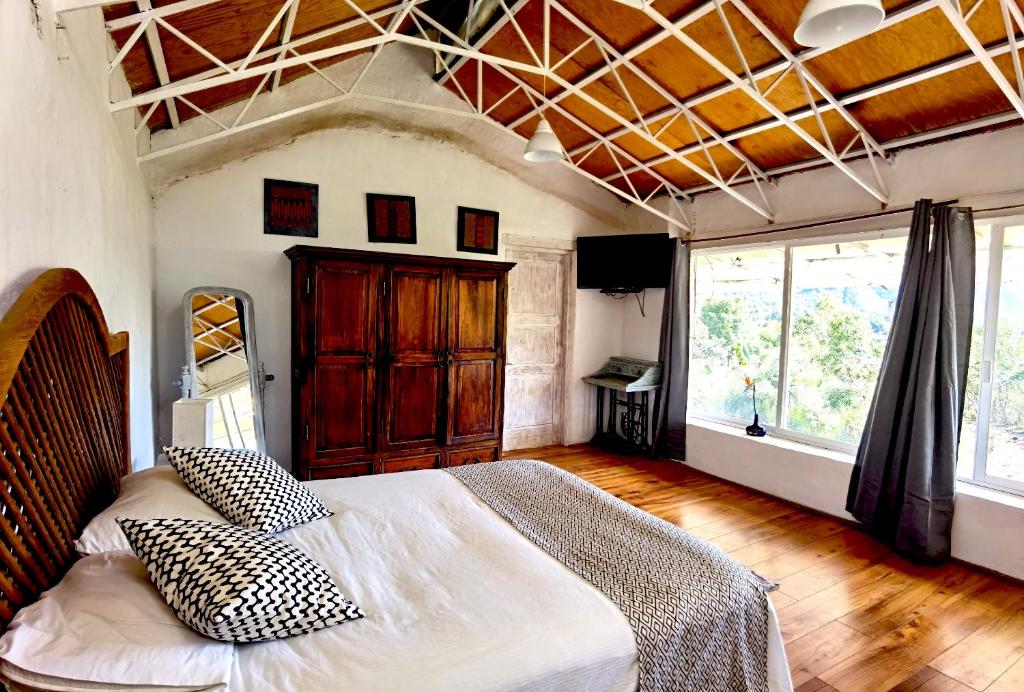 1 dormitorio con cama grande y ventana grande en Casa LUNAH Cabalgatas y Meditación, en Valle de Bravo