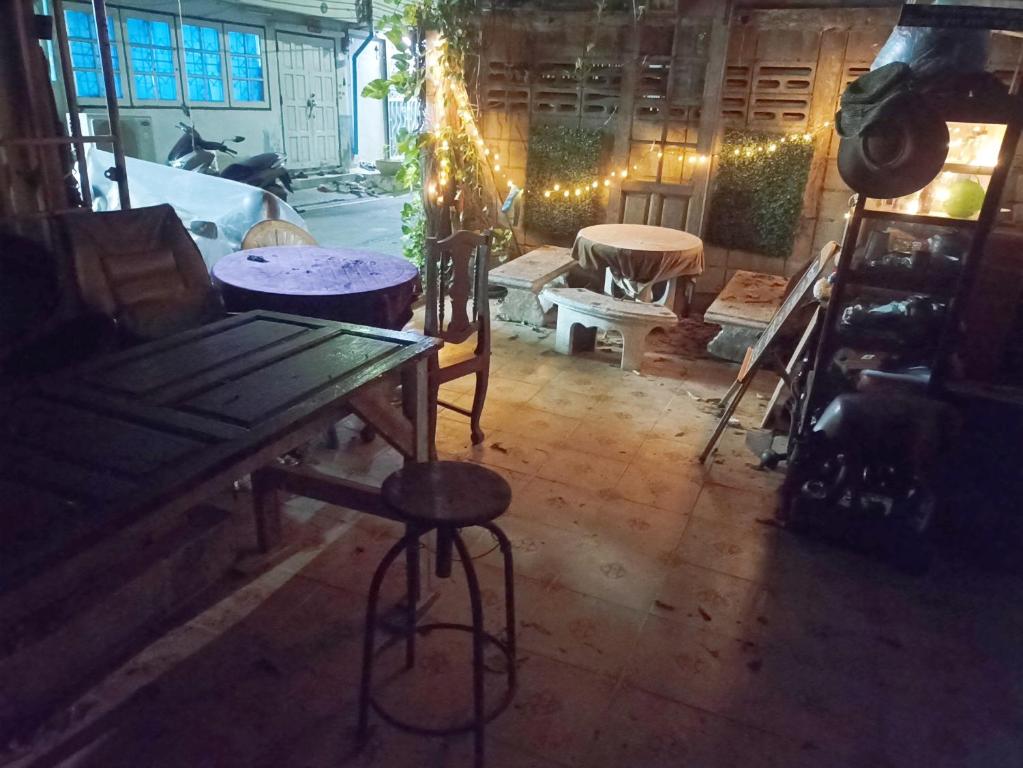 um quarto com uma mesa de madeira, cadeiras e luzes em GN GOOD NICE em Bangkok