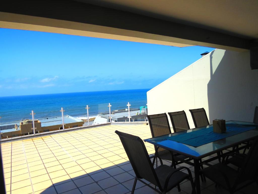 um pátio com uma mesa e cadeiras e o oceano em 5 Manaba Breeze em Margate