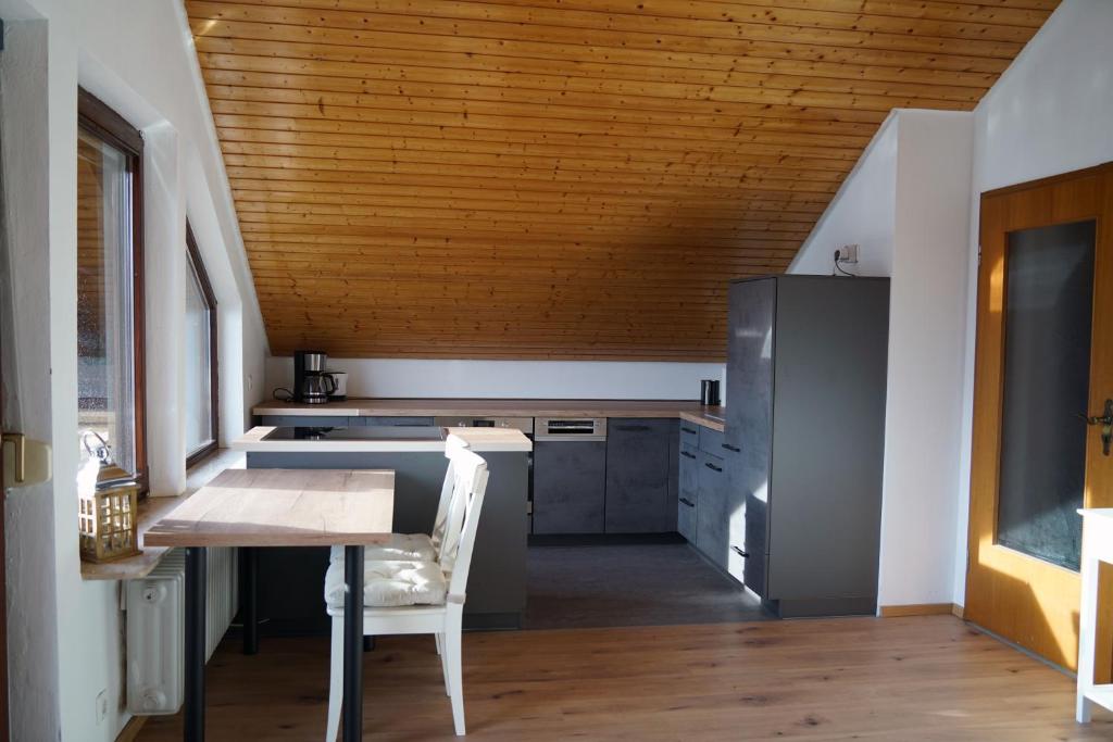 a kitchen with a table and a wooden ceiling at FeWo Horb Am Neckar in Horb am Neckar