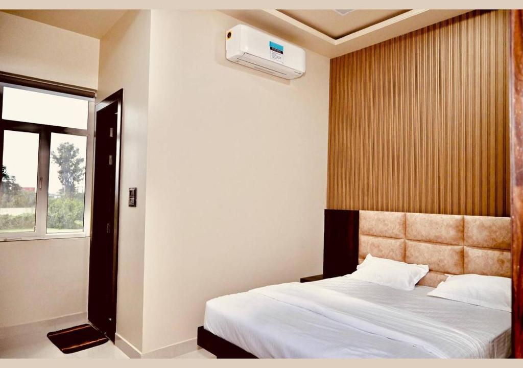 1 dormitorio con cama y ventana en Hotel Rameshwaram, Mathura, en Mathura