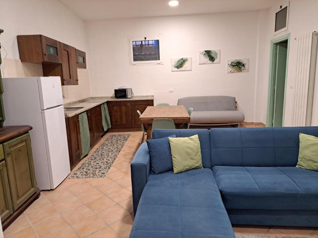 a living room with a blue couch and a kitchen at Casa Rosa in Finale Ligure