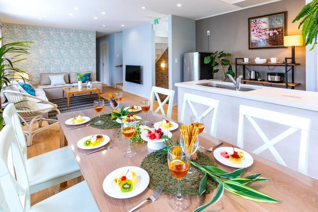 a dining room and kitchen with a table with food on it at ＼ビーチ×BBQ／沖縄での贅沢リゾートライフをお約束　遊び心をくすぐるキッズルームでお子様も大満足 in Meta
