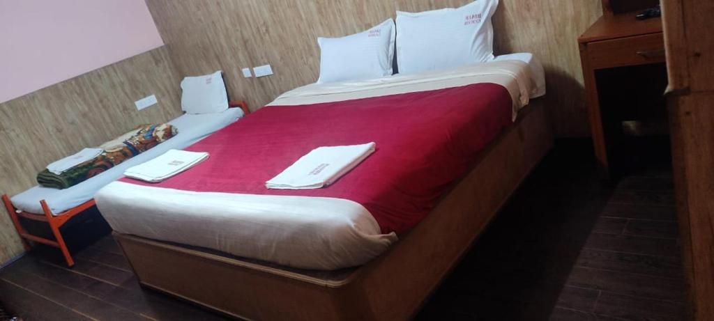 a hotel room with a large bed with two napkins on it at FLGHR Mg Grande Residency in Kodaikānāl