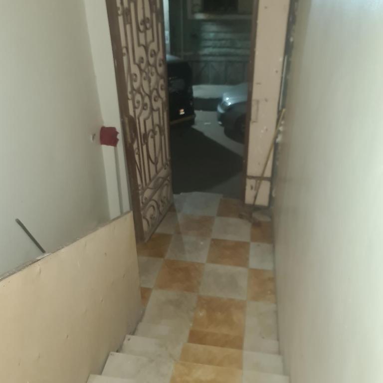 um corredor com uma porta e piso em azulejo em شقة مفروشة غرفتين بمدخل مستقل em Kafr Abū Dabbūs