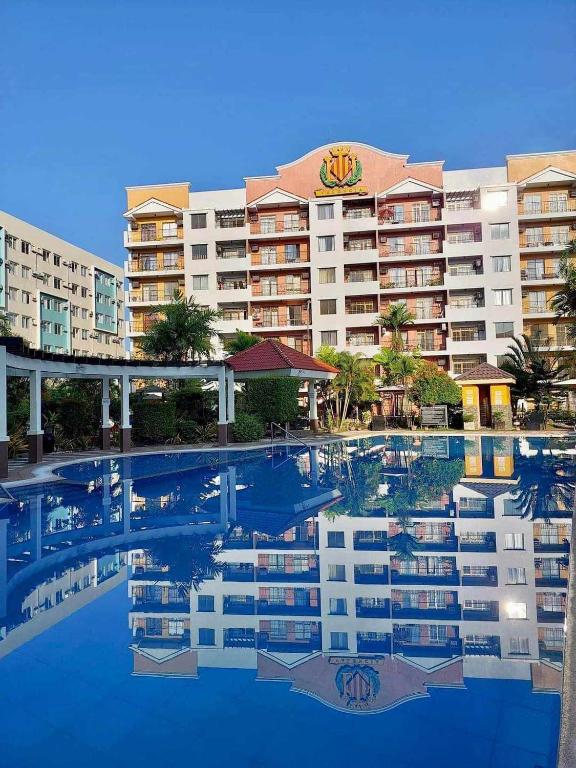 a reflection of a building in a swimming pool at 2BR Kelsey Haven With Balcony in Davao City