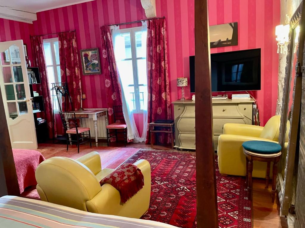 - un salon avec des murs roses et un mobilier jaune dans l'établissement JOHA DOMA, à Lunel