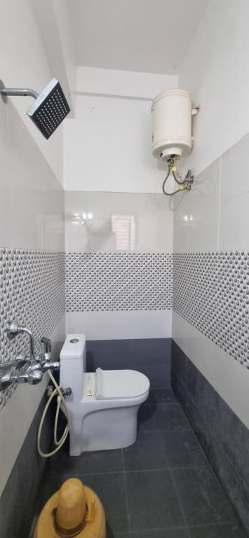 a bathroom with a white toilet and a sink at Veda Residency in Machilīpatnam