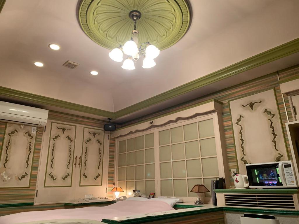 Iwakiriにあるホテル　プレリュードのベッドとシャンデリアが備わる客室です。