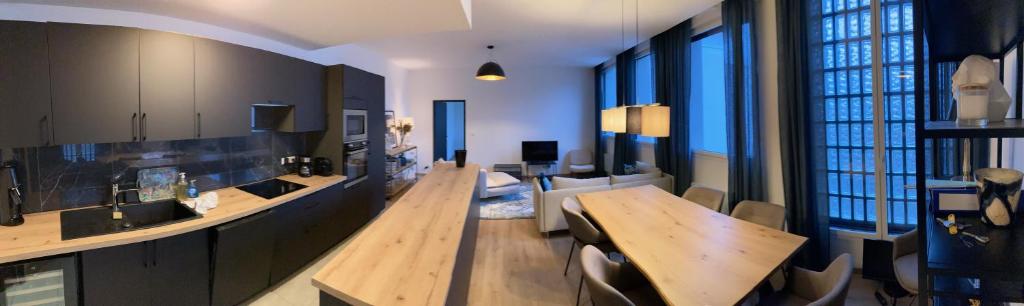 Appartement de charme + parking centre-ville Arras في أراس: غرفة معيشة مع طاولة وغرفة طعام