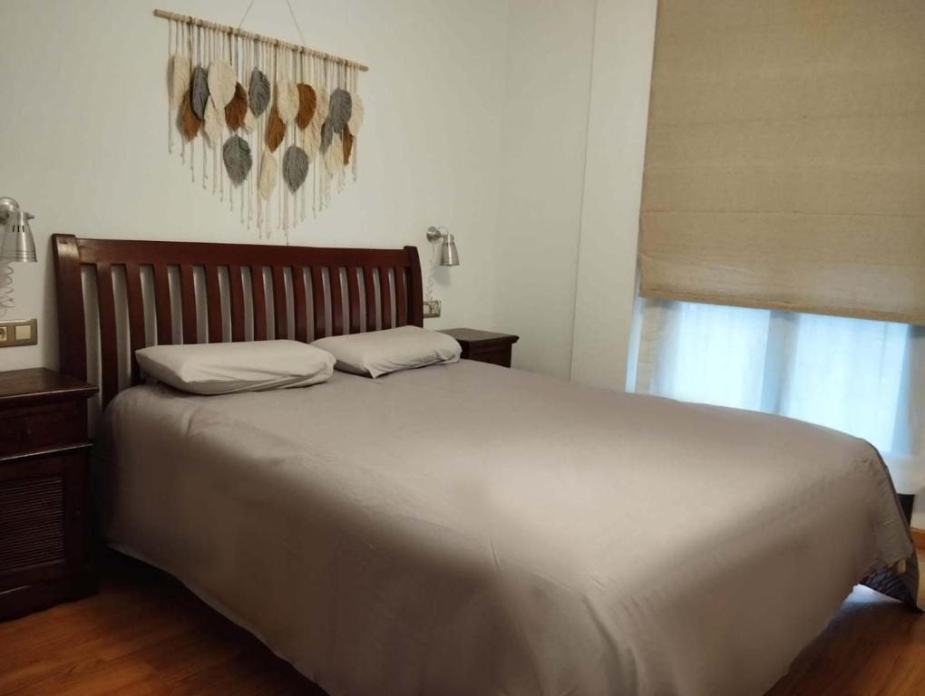 Un dormitorio con una cama grande y una ventana en Acogedor Apartamento Céntrico en La Puebla de Valverde