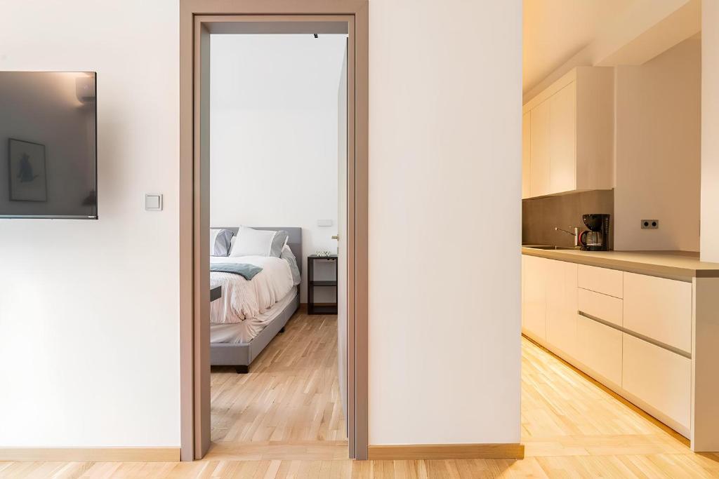 1 dormitorio con una puerta corredera que conduce a una cama en Serenity & Luxury - Elegant 2BR in Kifisia's Center en Athens