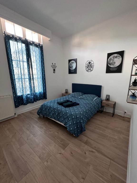 a bedroom with a bed and a wooden floor at L évasion centre ville famille in Auxerre
