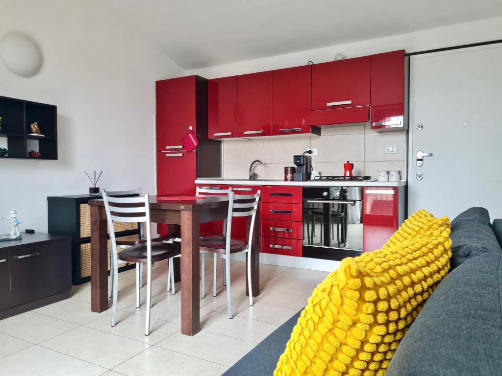 a kitchen with red cabinets and a table and chairs at La casa di Laura in Seregno