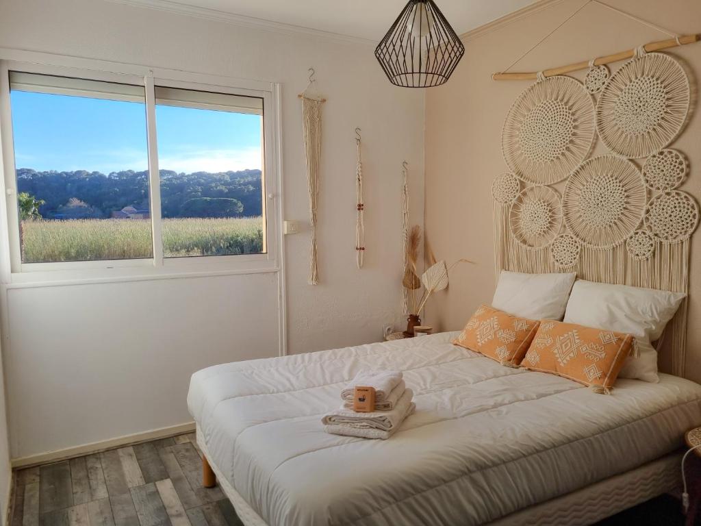 een slaapkamer met een groot bed en een raam bij T3 De Charme - avec clim, parking et piscine in Le Lavandou