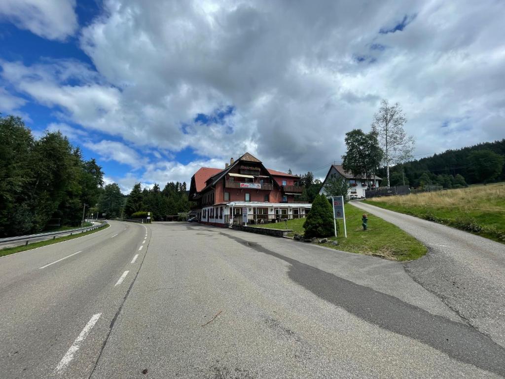 eine leere Straße mit einem Haus an der Seite in der Unterkunft Hotel Faller in Breitnau