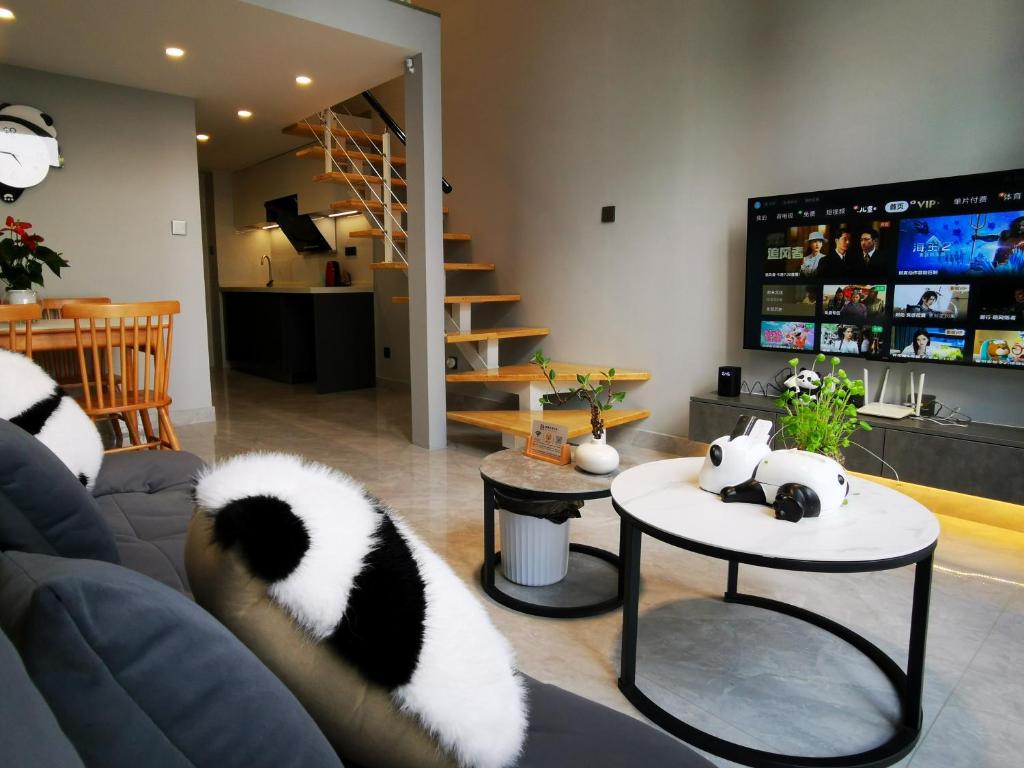 a living room with two pandas laying on a couch at Panda ZuoKe Besucher Apartment 熊猫坐客民宿 in Kunming