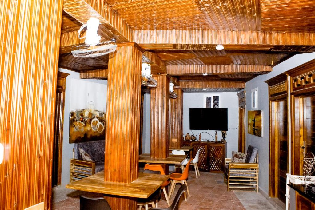 a dining room with a table and a tv at Swahili Homes- Ada Estate in Dar es Salaam