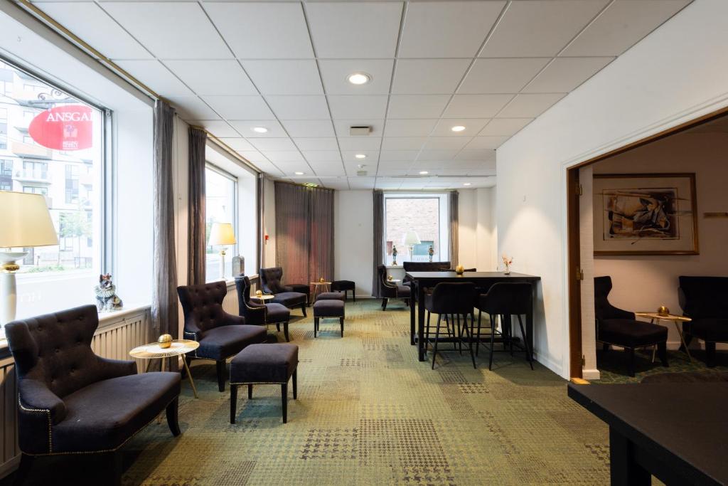a waiting room with a table and chairs at Milling Hotel Ansgar in Odense