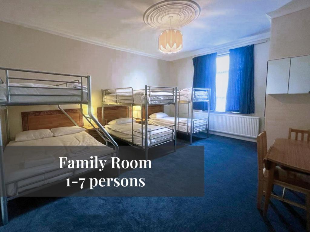 um quarto com 2 beliches e alcatifa azul em Helen's Hotel em Londres
