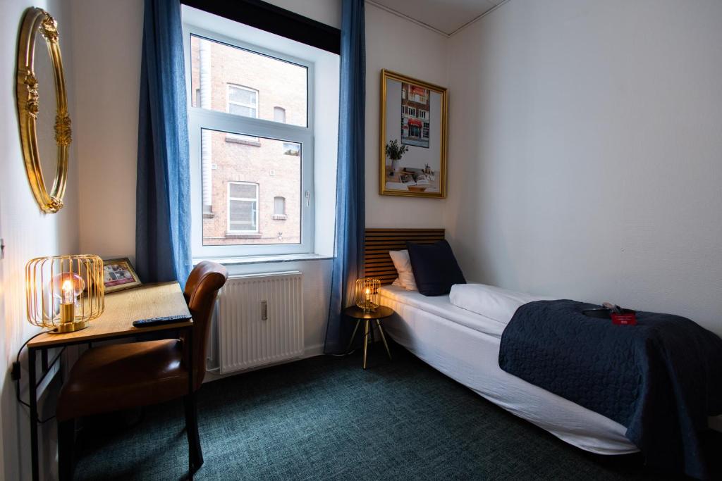 a bedroom with a bed and a window at Milling Hotel Ansgar in Odense
