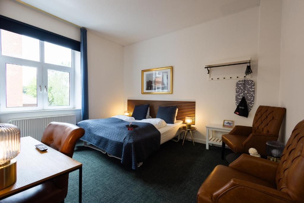 a bedroom with a bed and a chair at Milling Hotel Ansgar in Odense