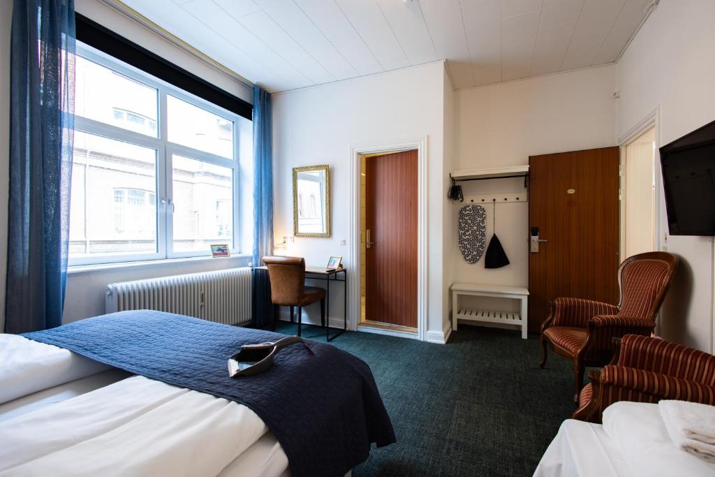 a hotel room with two beds and a window at Milling Hotel Ansgar in Odense