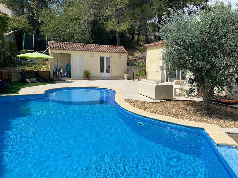une grande piscine bleue devant une maison dans l'établissement Spacieuse villa avec piscine proche Pic Saint Loup, à Prades-le-Lez