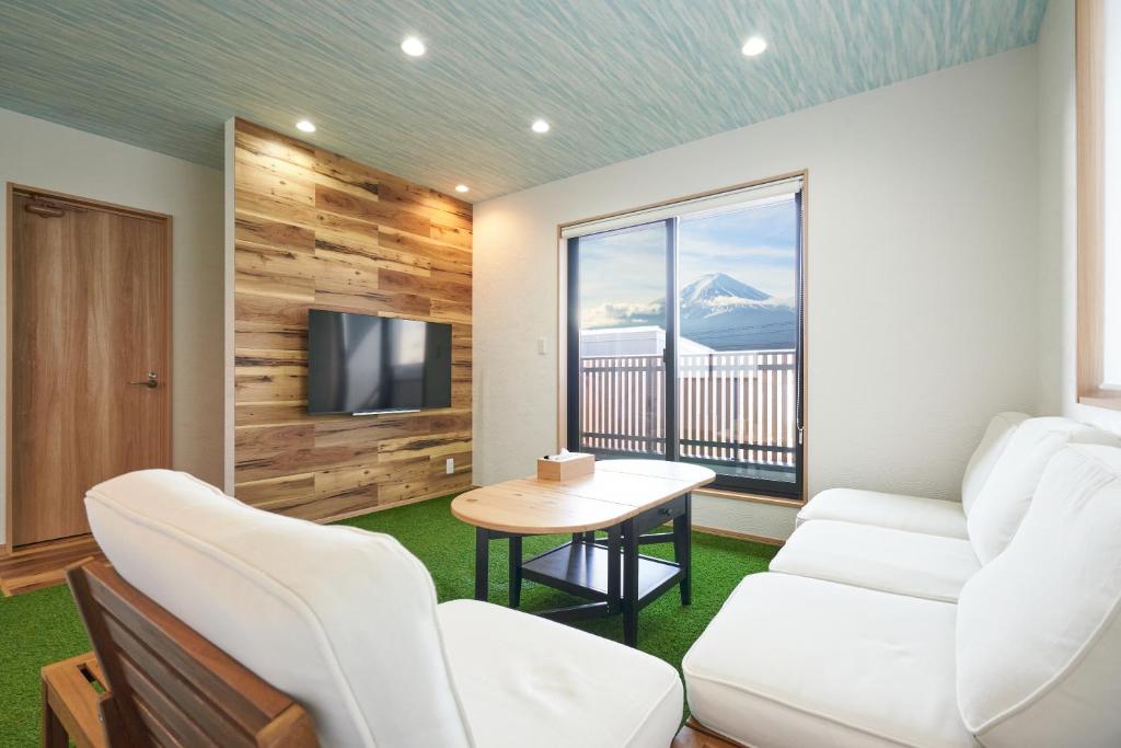 a room with white chairs and a table and a television at 09 Resort Club -Green- in Azagawa