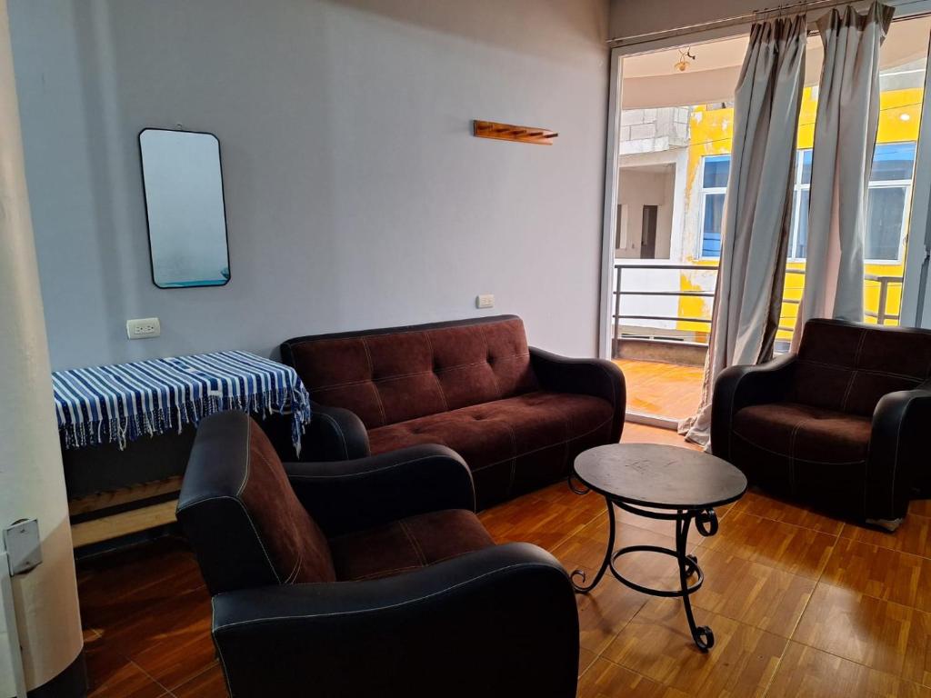 een woonkamer met een bank, stoelen en een tafel bij Apartamento Conchita Gris in San Pedro La Laguna