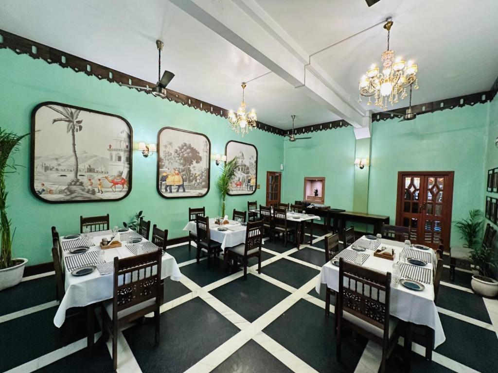 a dining room with tables and chairs and green walls at RAGHVENDRA HERITAGE in Jodhpur