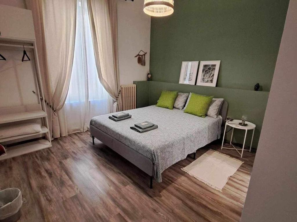 una camera con letto e parete verde di AUXIMUM Appartamenti a Osimo