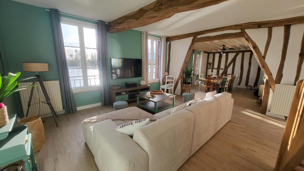 a living room with a white couch and a table at Le Cœur du Bien-être - Gîte grande capacité - Superbe emplacement - Vue Seine - Décoration soignée - Coin touristique in Les Andelys