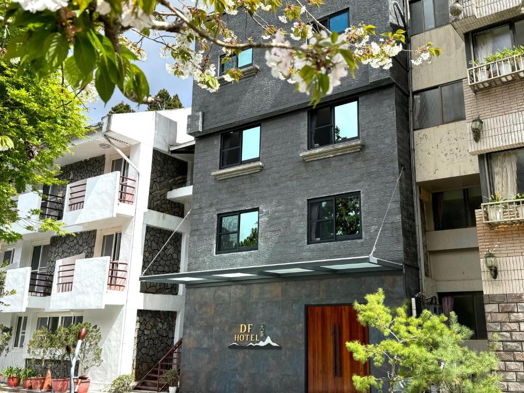 an apartment building with a gray facade and a door at Dafong Hotel in Zhongzheng