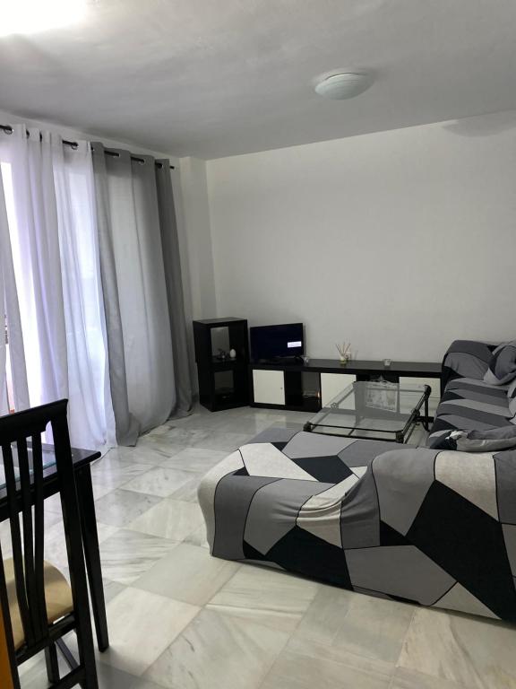Un dormitorio con una cama y una mesa dentro. en Cataleya, en Nerja