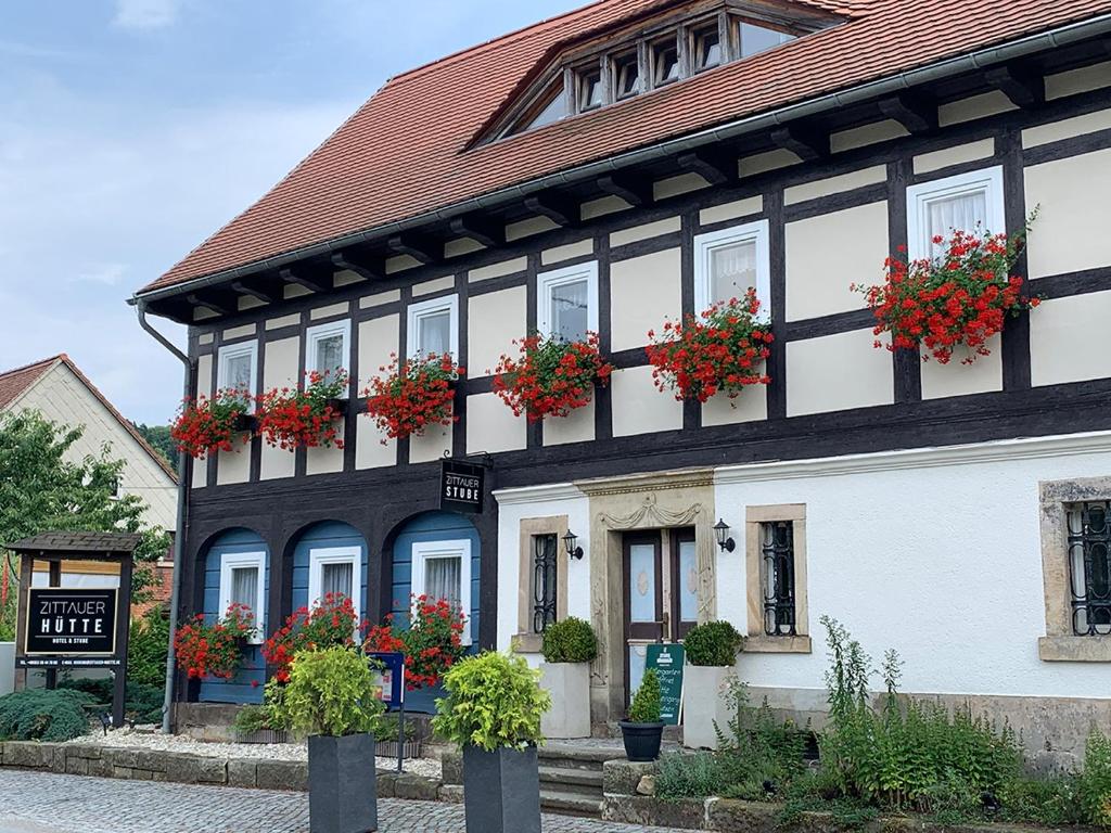 a black and white building with flowers in the windows at Hotel Zittauer Hütte in Kurort Jonsdorf