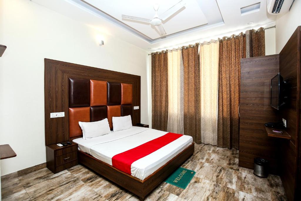 a bedroom with a bed with a red and white blanket at The Woodlark !! Managed by Sidham Hospitality !! in Chandīgarh