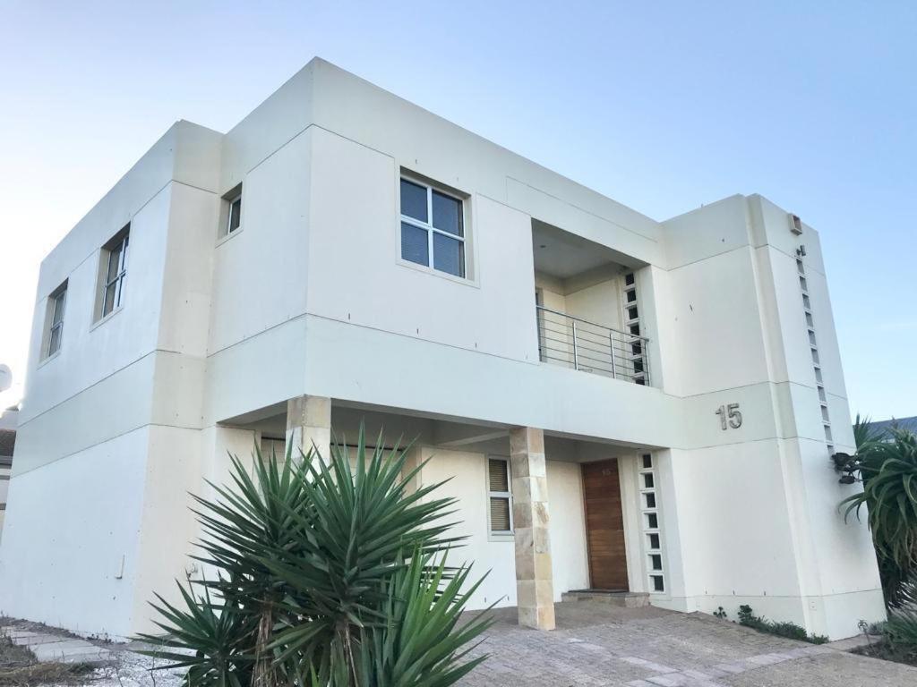 a white building with trees in front of it at Calypso Beach Holiday House in Langebaan