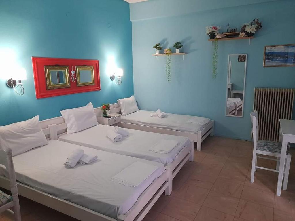 Zimmer mit 2 Betten und einem Spiegel in der Unterkunft Faros in Platamonas