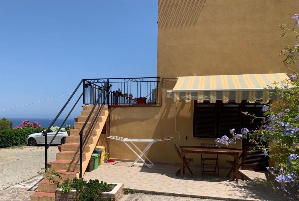 ein Haus mit einem Tisch und einer Treppe sowie einem Balkon in der Unterkunft Monolocale “La Panoramica” in Rio Marina