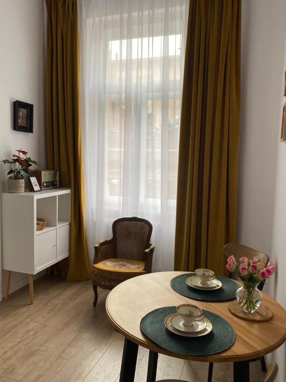 Hey Central Apartment في تيميشوارا: غرفة معيشة مع طاولة وكراسي ونافذة